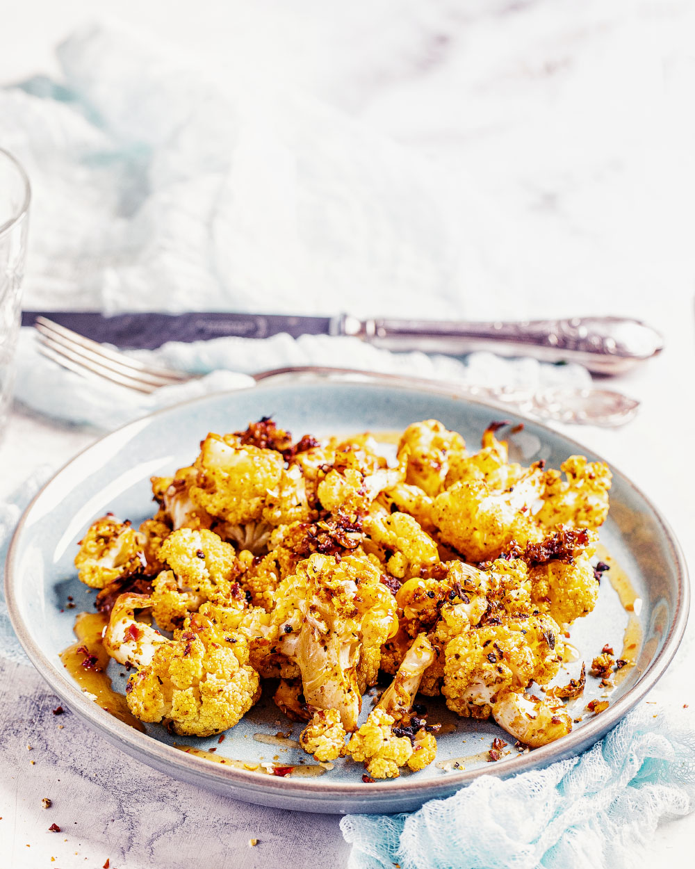 Goldbraun geröstete Blumenkohlröschen auf einem Backblech mit Gewürzen