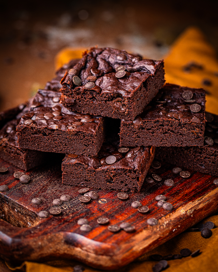 Protein Brownies in einer Backform, in 9 Stücke geschnitten, mit Schokodrops auf der Oberfläche