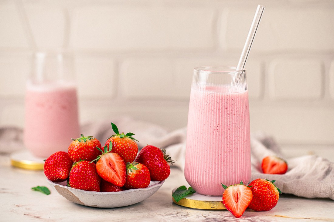 Erdbeer-Proteinshake von oben mit frischen Erdbeeren