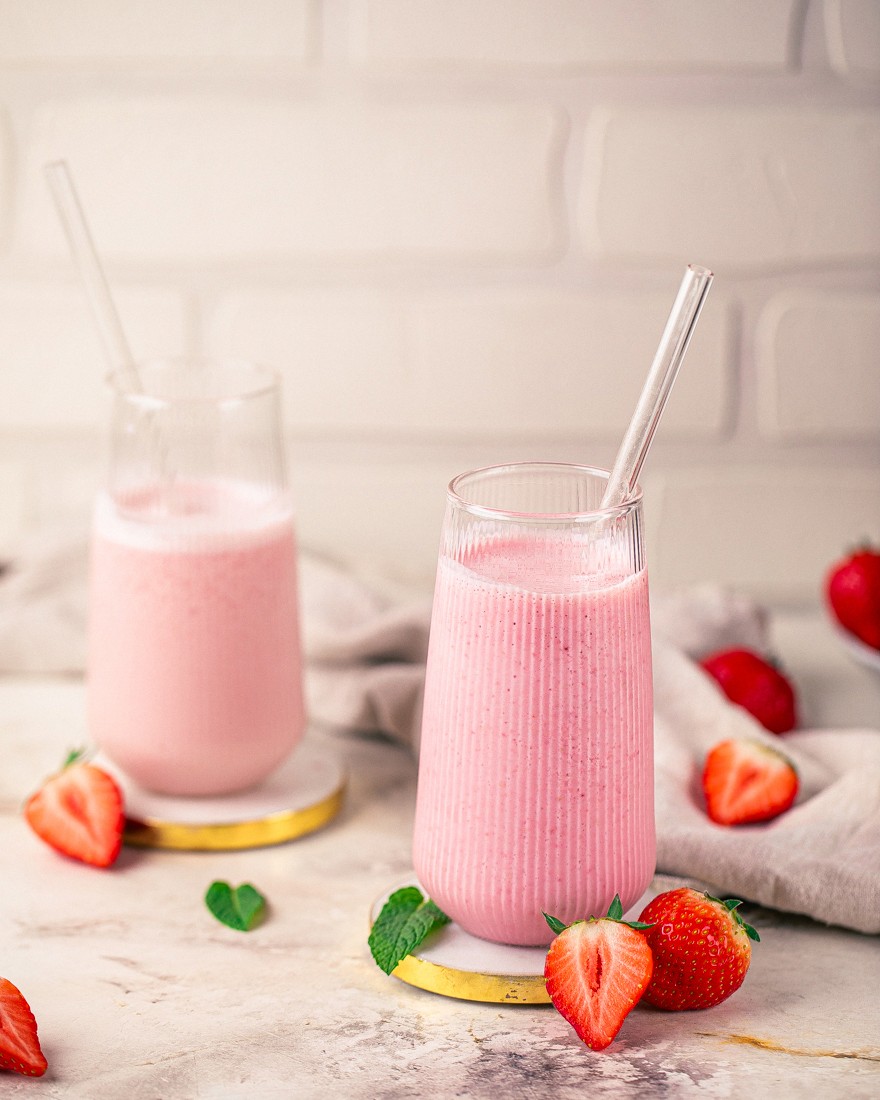 Erdbeer-Proteinshake im Glas mit Strohhalm